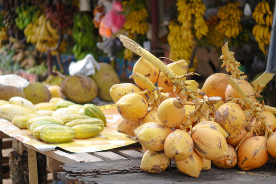 Yellow coconuts are sold on the market in Asia. Sale of vegetarian fruits outdoors. Stock photo