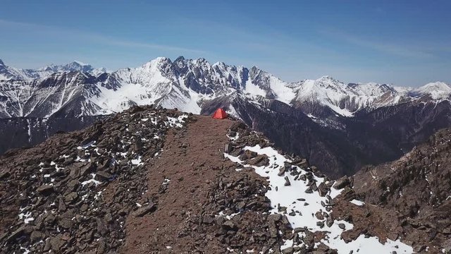 Drone shot orbiting a shelter tent on top of the mountain. Baikal, Siberia
