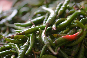 Green and red peppers on the asia market. Vegetarian theme and chili spices.