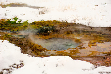 Obraz premium A Small Geysir With Steaming Water In This Snow Covered Geothermal Area