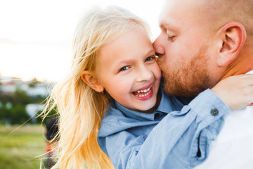 Fototapeta premium Happy father and child spending time outdoors. Beautiful blonde daughter.