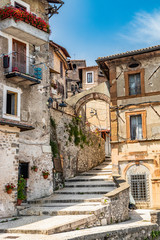 Fototapeta na wymiar The stairways and cobbled alleys that lead to the ancient village of Artena. Old buildings with brick and stone walls. Arches, windows and doors. Real estate. Rome, Lazio, Italy.