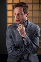 Portrait eines selbstbewussten jungen Mannes im grauen eleganten Anzug