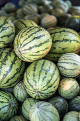 Watermelons and melons are sold on the market in Asia. Sale of vegetarian fruits outdoors. Stock photos