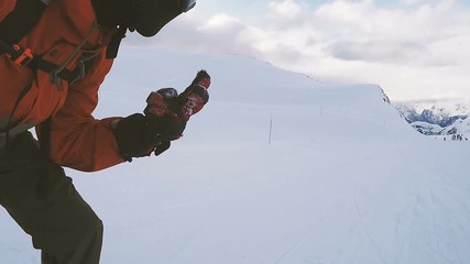 Snowboarder showing peace sign and going down the slope.