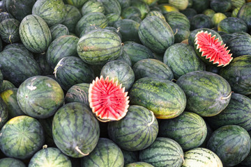Fototapeta na wymiar Watermelons and melons are sold on the market in Asia. Sale of vegetarian fruits outdoors. Stock photos