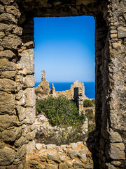 View through a window of a ruin at the seaside at sunshine.