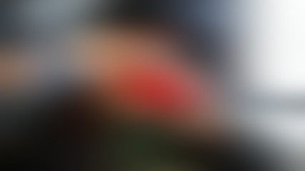 Red spot on a gray abstract blurred dark gradient background.