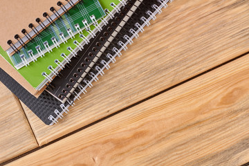 Spiral notebooks on wooden table with copy space. A pile of metal ring binder notebooks on wooden background. Work or education concept.