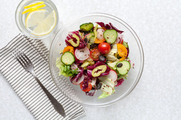 Fresh salad with lemonade on white table