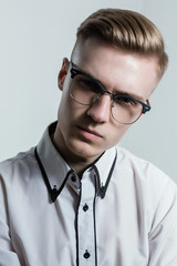 Serious blonde man in the optical glasses with black rim. Optics concept