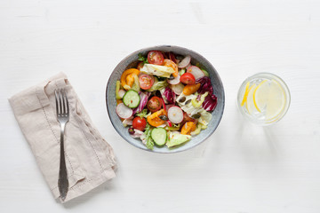 Healthy salad with vegetables on white table. Top view