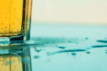 Bubbling yellow fizzy soda drink in glass, close up