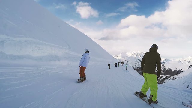 Snowboarding in snowy mountains. Mountain ridge in the background.