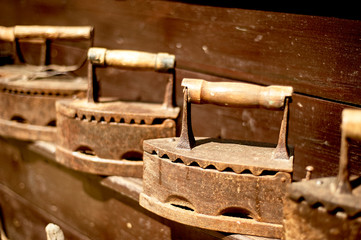 Old metal rusty vintage iron. On coals. The old device for Ironing clothes