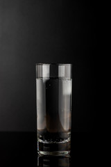 Glass of water on black background