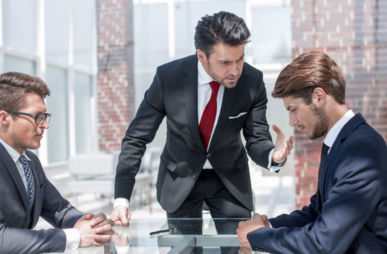 annoyed businessman scolds his employees