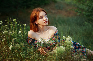 Outdoor portrait of a young beautiful girl in a summer dress , model on a green meadow