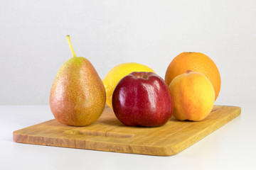 red apple, pear, lemon, orange, peach on white background, copy space