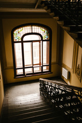 Obraz premium Inside a residential building with a staircase and a window.