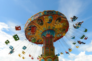 June 10, 2018: Children ride on the carousel in an amusement park against a blue sky. Cheboksary....