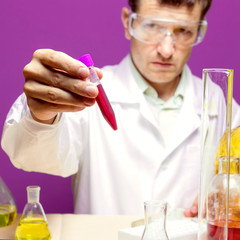 Lab technician looking at a flask with chemicals