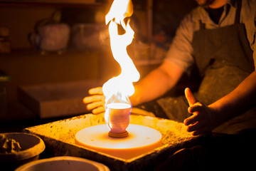 Burning ceramic mug on pottery wheel