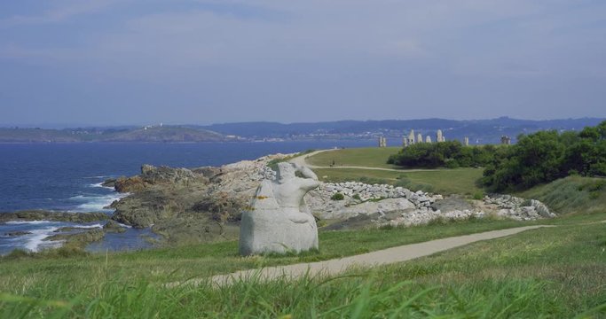 Monumento H&eacute;rcules en la nave de los Argonautas whit people walking - Menhires and dolmenes in Parque Escult&oacute;rico de la Torre de H&eacute;rcules de La Coru&ntilde;a  - 4k - A coruna - Monument