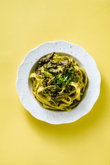 fresh italian pasta tagliatelle with porcini mushrooms in a plate on a white background
