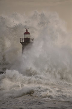 tormy wave splash covering lighthouse at sunset © Zacarias da Mata