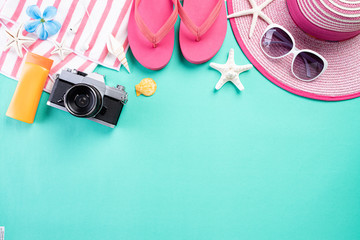 Fototapeta na wymiar Beach accessories retro film camera, sunglasses, flip flop starfish beach hat and sea shell on green pastel background for summer holiday and vacation concept.