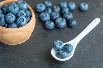 Many fresh bluederrys on the blacktable close up