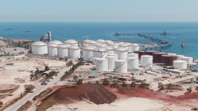 Aerial drone footage of the large fuel gas power station on the coastline of Mediterranean sea. Cyprus island with industrial factory at seaside on a sunny summer day.