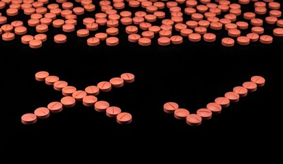 Orange colour round pills on black background with selective focus. Pills that look like ecstasy.