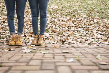 Close up of two women in boots standing in the park