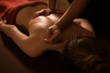 Young woman enjoying massage at spa salon
