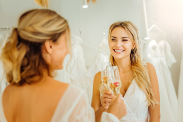 Two brides clanging glasses of champagne together.