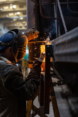 Fototapeta premium Welder repairs freight car in railway depot