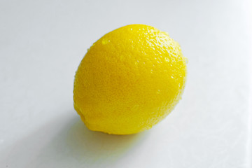 One fresh lemon on white kitchen table
