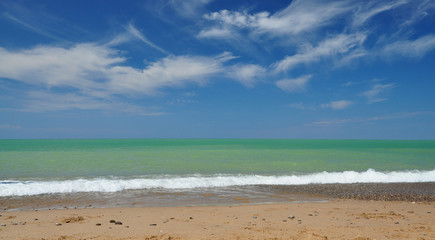 Azure sea, beach, blue sky with feather clouds