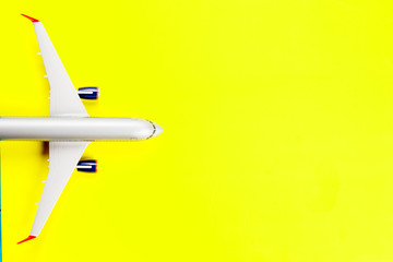 Travel, vacation concept. Top view of plane on yellow color background with free space for your text. Mockup for travel project.