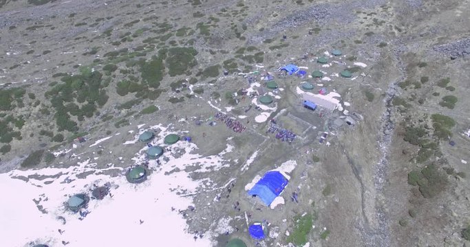Aerial shot of camping tents on the high altitude Himalayas, Uttarkashi, Uttarakhand India. Snowy mountains. Mesmerizing nature view.Tent pitched for Himalayan mountaineers to stay.