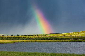 Regenbogen über einem See in Norwegen