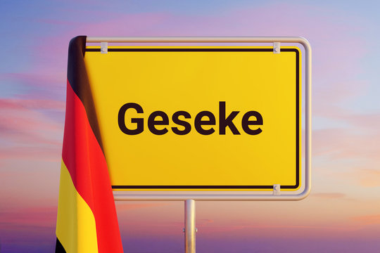 Geseke. Gelbes Schild/Ortsschild. Flagge von Deutschland hängt darüber. Himmel mit Sonnenuntergang oder Sonnenaufgang