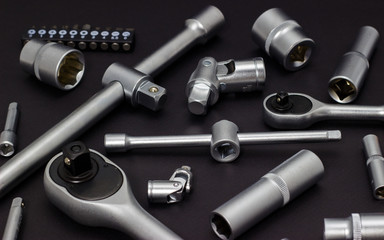 Obraz premium A set of tool heads for loosening screws, bolts and nuts. Ratchet screwdriver. Dark background.