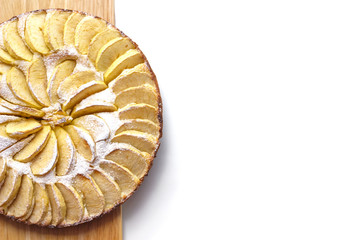 Homemade apple cake dusted with icing sugar lies on a wooden board top view free space for text