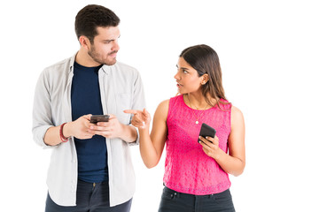 Woman Confronting Boyfriend With Smartphone In Studio