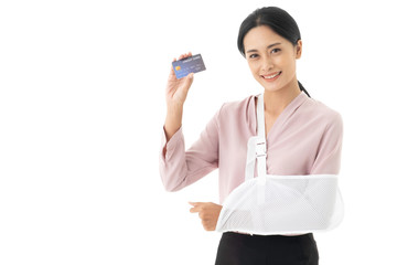 Beautifu young Asian woman is injured with a broken arm and put on arm sling. Which shows a credit card, Accident insurance business concept.