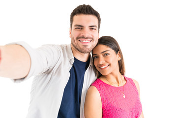 Fototapeta premium Smiling Couple Taking Self Portrait In Studio