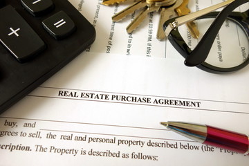 Real estate purchase agreement for filling with pen calculator keys and glasses